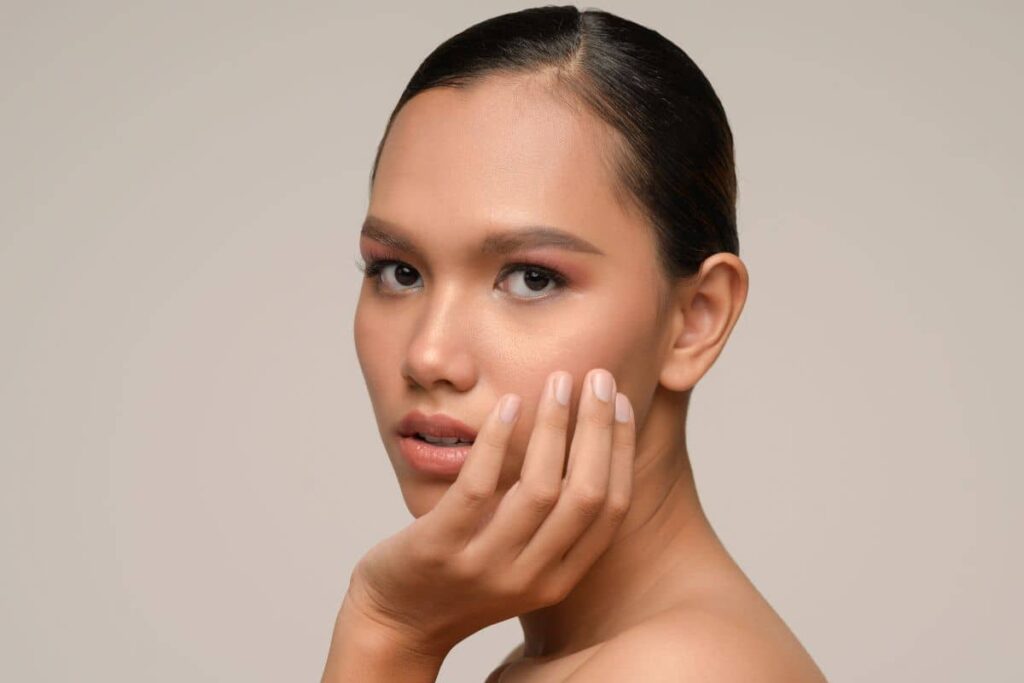 Woman with clear skin and defined features, representing recovery stage and gradual results after rhinoplasty procedure.