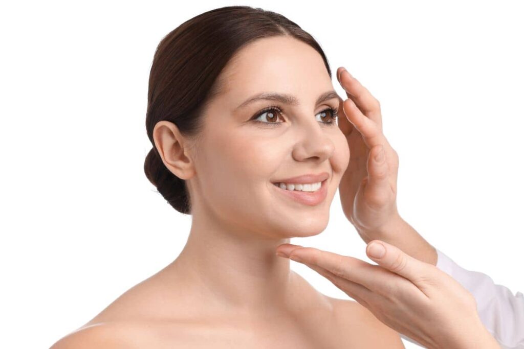 Smiling woman being evaluated by facial plastic surgeon, emphasizing importance of experience in crooked nose correction